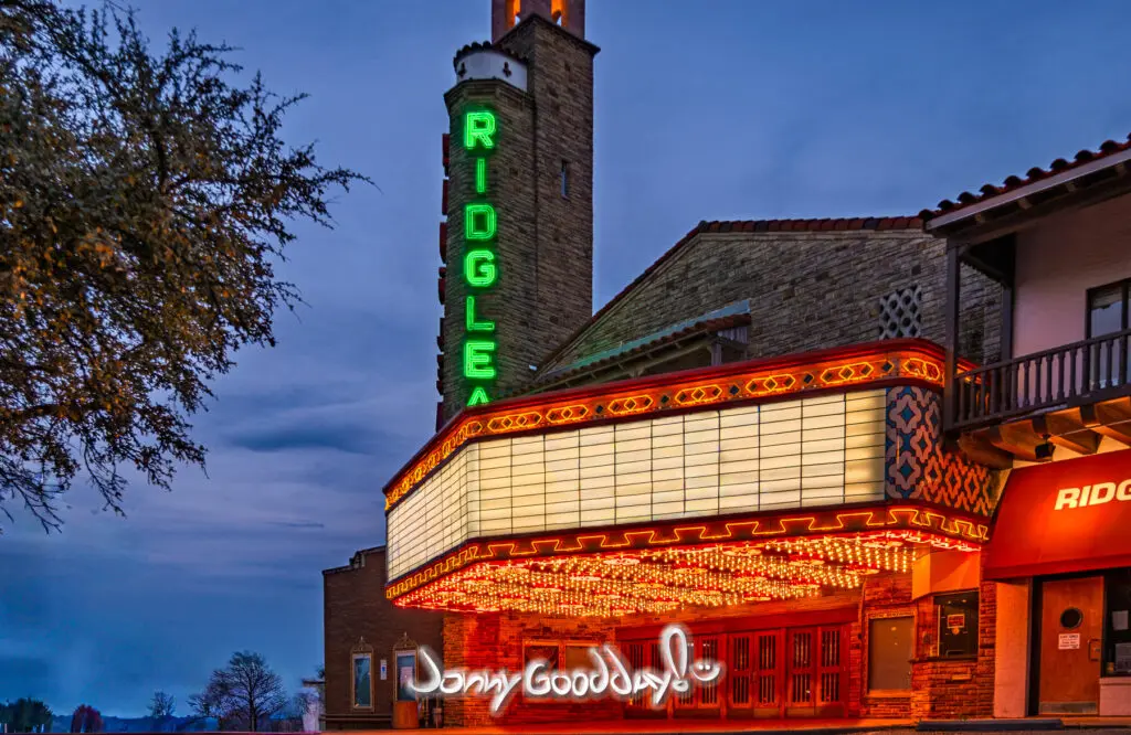 The illuminated Ridglea Theater marquee and green neon tower at dusk in Fort Worth, Texas.
