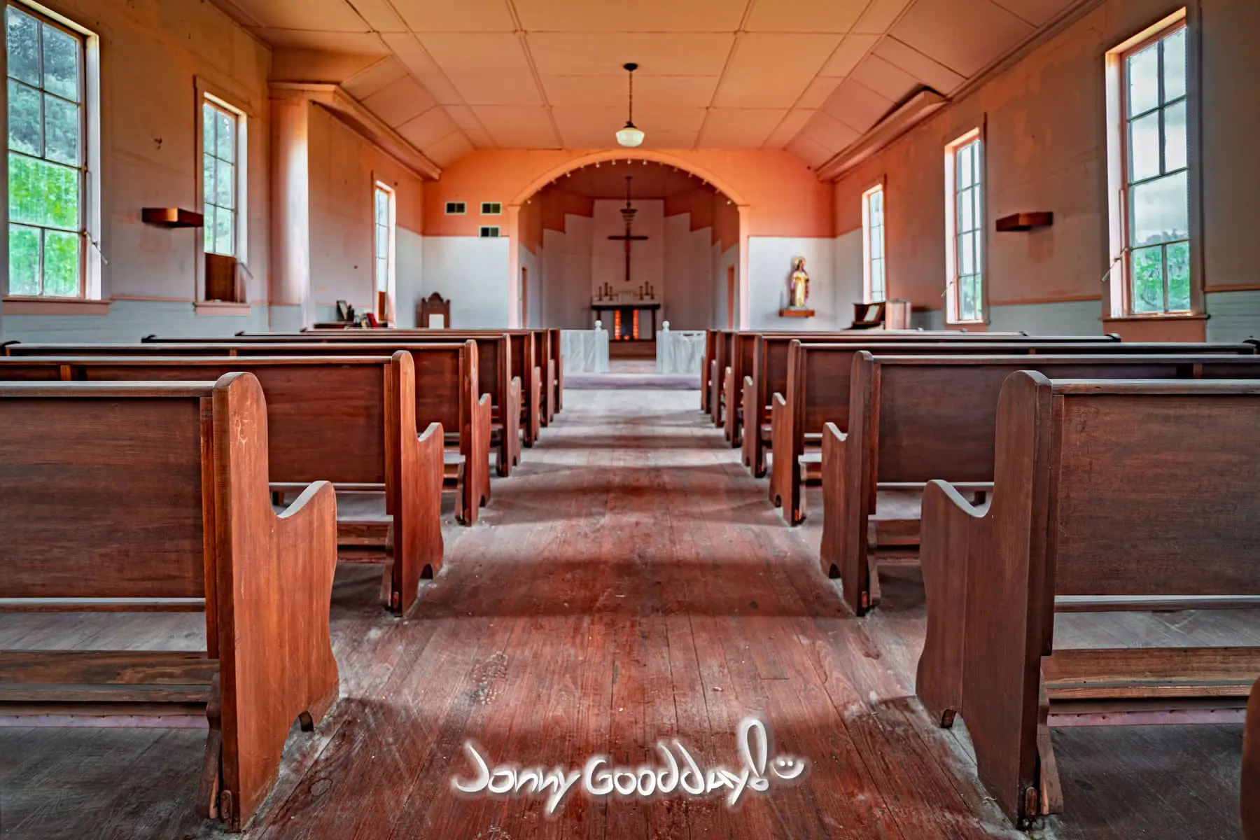 The center aisle, wooden pews, and altar inside St. Barbara’s Catholic Church in Thurber, Texas.