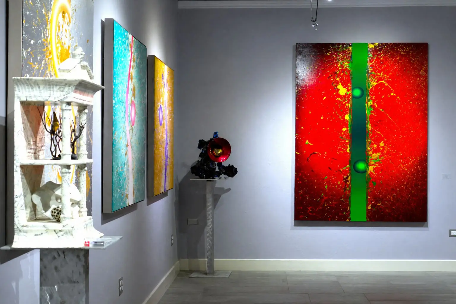 Colorful paintings and sculpture displayed inside Museo Benini