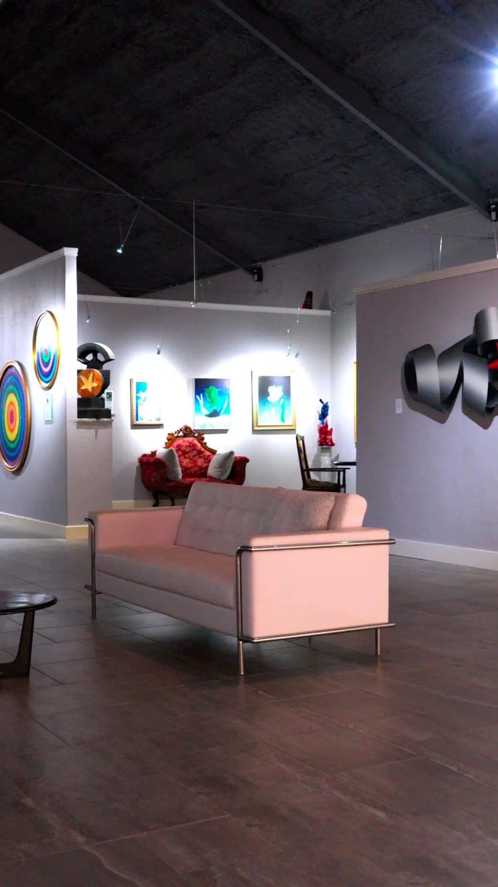 Interior gallery at Museo Benini with paintings, sculpture and seating